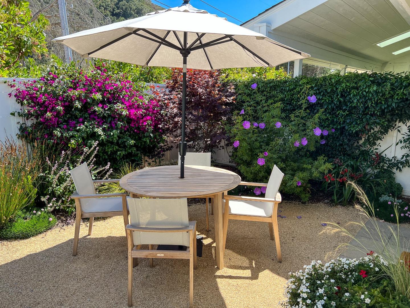 28060 Robinson Canyon Road Carmel, CA 93923 - Photo 17 of 36 a table and chair under an umbrella in backyard