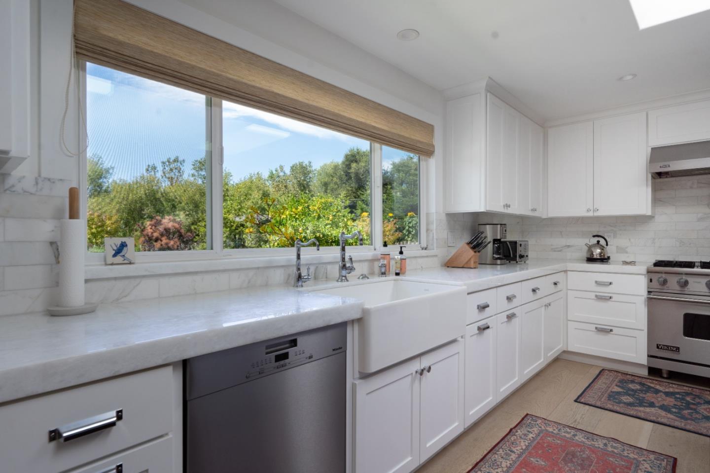 28060 Robinson Canyon Road Carmel, CA 93923 - Photo 23 of 36 a kitchen with stainless steel appliances white cabinets a sink and a large window