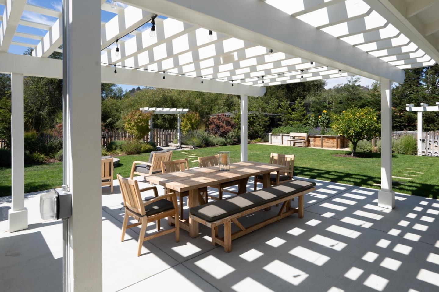 28060 Robinson Canyon Road Carmel, CA 93923 - Photo 35 of 36 a view of a patio with table and chairs potted plants and large tree