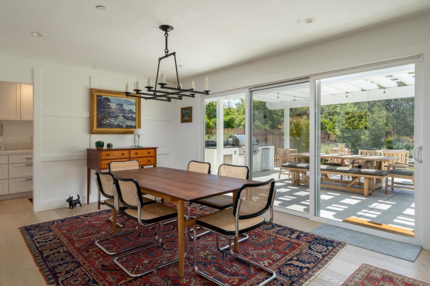28060 Robinson Canyon Road Carmel, CA 93923 - Photo 10 of 36 a dining room with furniture a chandelier and wooden floor