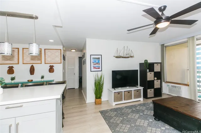 a living room with a flat screen tv and a white refrigerator