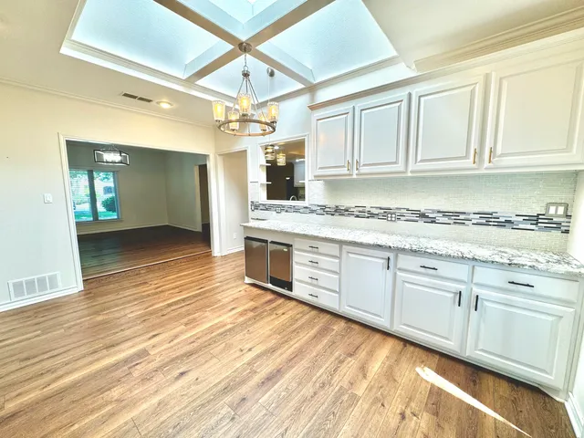 a kitchen with stainless steel appliances granite countertop a sink cabinets and wooden floor