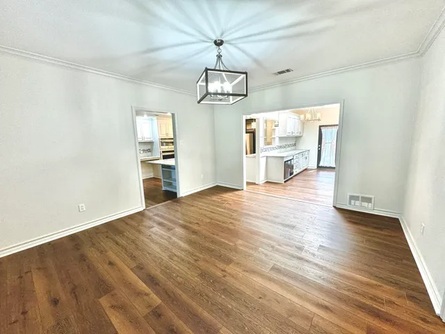 a view of a kitchen with wooden floor and a chandelier fan