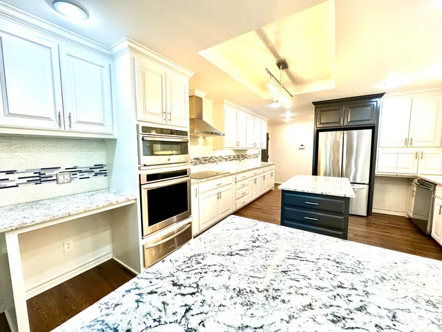 a kitchen with stainless steel appliances kitchen island granite countertop a stove and cabinets