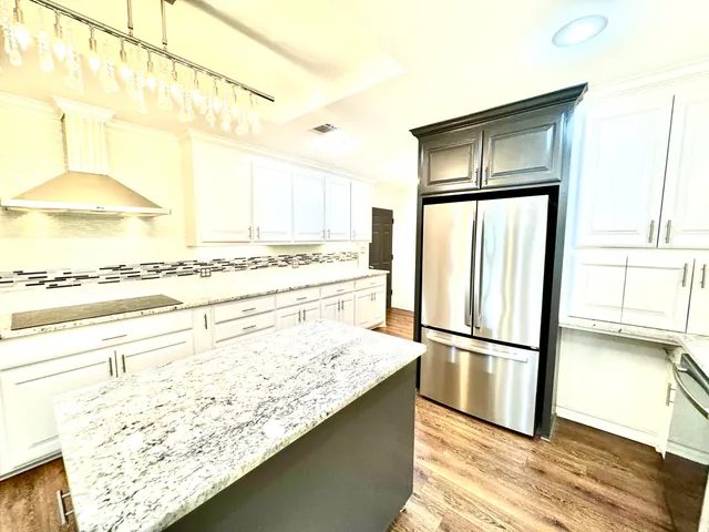 a view of a kitchen with wooden floor and cabinets