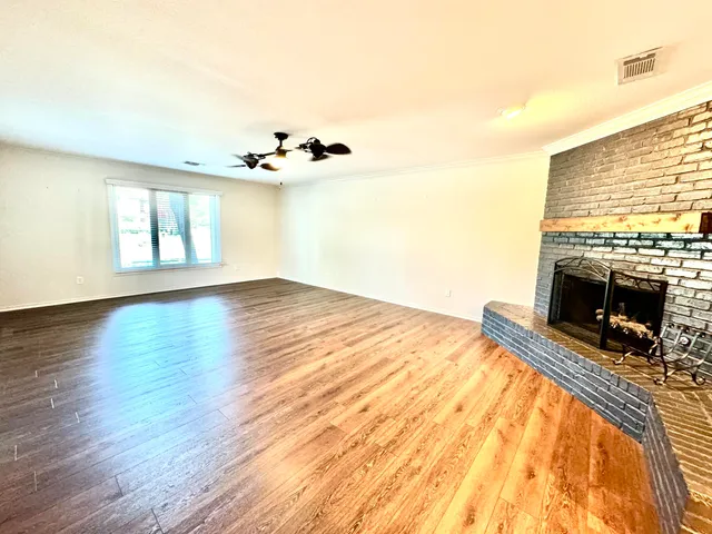 a view of a livingroom with wooden floor and a fireplace