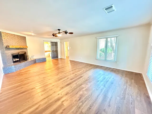 an empty room with windows and fireplace