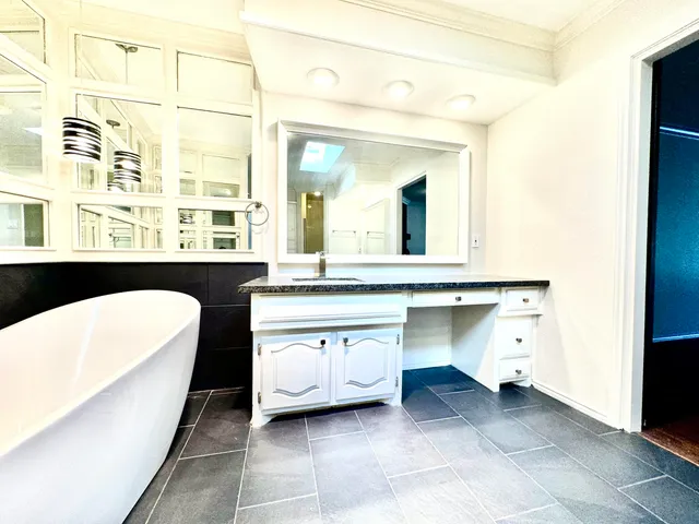 a view of living room with a sink and dishwasher with a large mirror next to a window