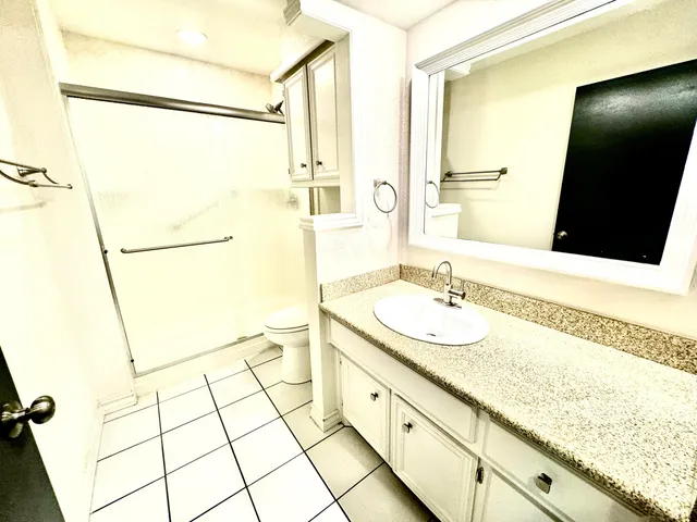 a bathroom with a granite countertop sink and a mirror