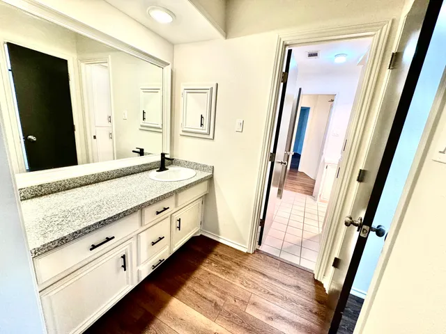a bathroom with a granite countertop sink and a mirror