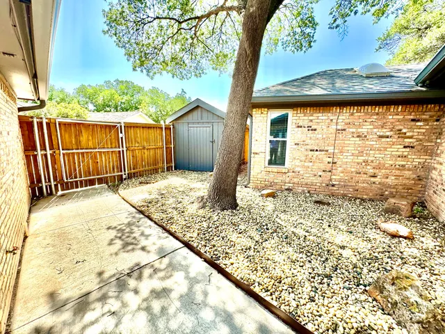 a view of a backyard with a tree