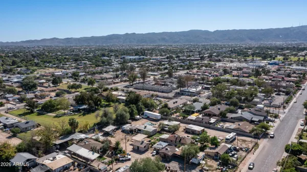 an aerial view of residential houses with outdoor space and trees