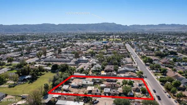 an aerial view of residential houses with outdoor space and trees