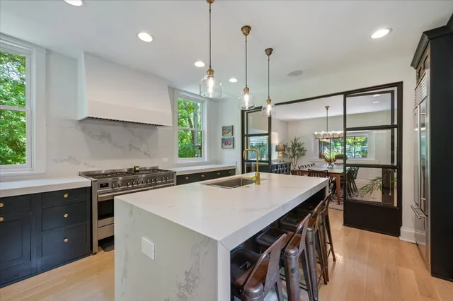 a kitchen with a stove a sink a center island and a window