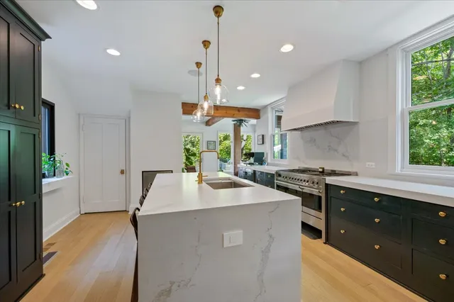 a kitchen with stainless steel appliances granite countertop a sink a stove and a refrigerator