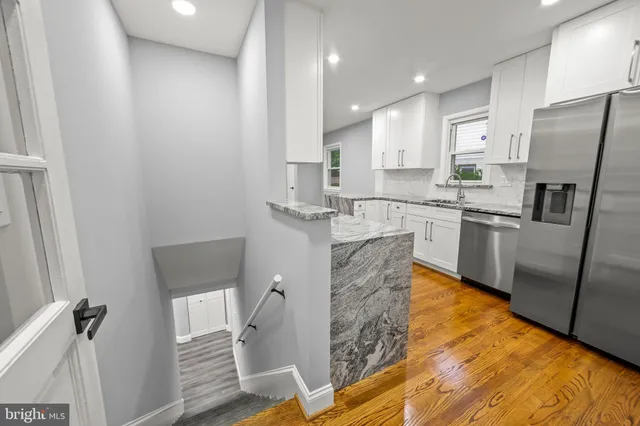 a kitchen with stainless steel appliances granite countertop a refrigerator and a stove top oven