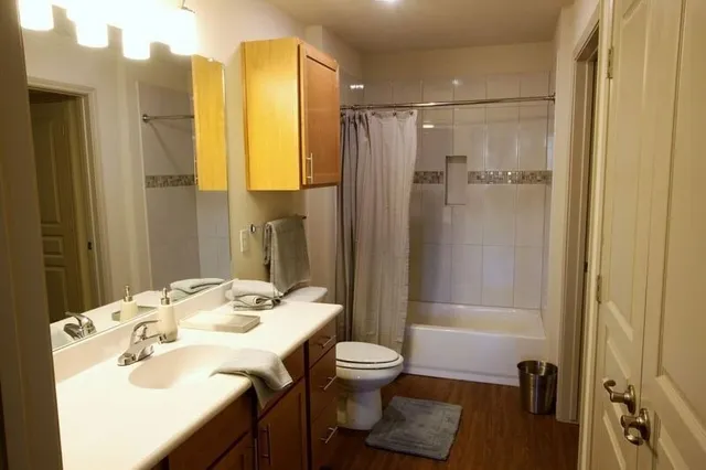 a bathroom with a granite countertop sink toilet and shower