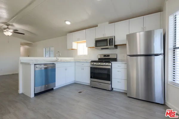 a kitchen with stainless steel appliances a refrigerator stove and microwave