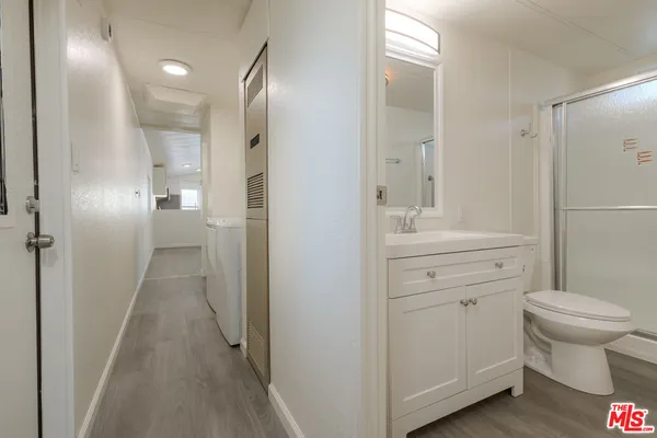 a bathroom with a sink toilet vanity and shower