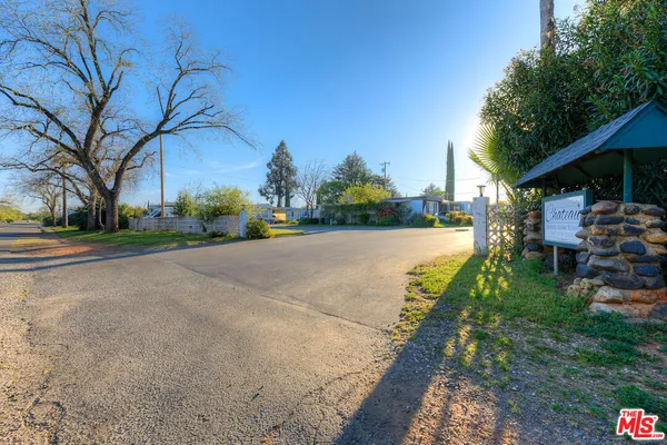 a view of a street with a building and trees in the background
