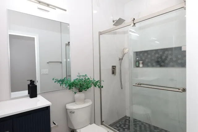 a bathroom with a granite countertop sink toilet and shower