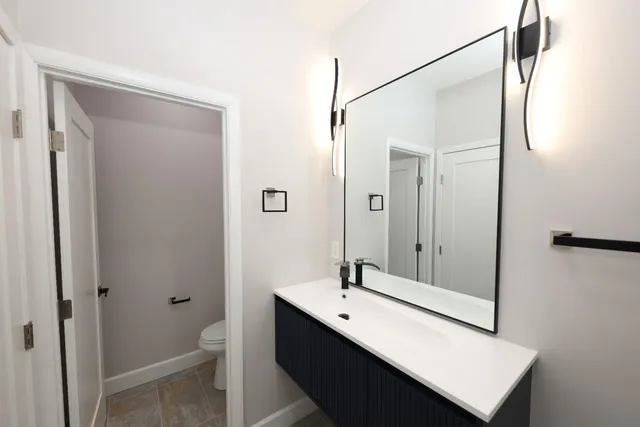 a bathroom with a double vanity sink a toilet and a mirror