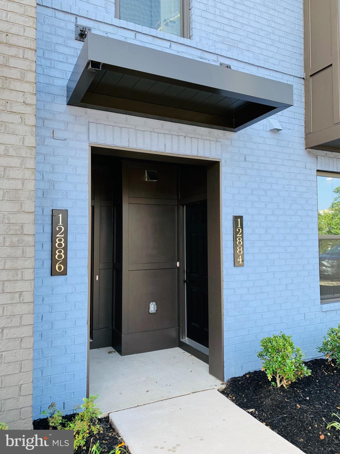 12884 Sunrise Ridge Alley, Unit 47 Herndon, VA 20171 - Photo 1 of 37 a front view of a house with plants