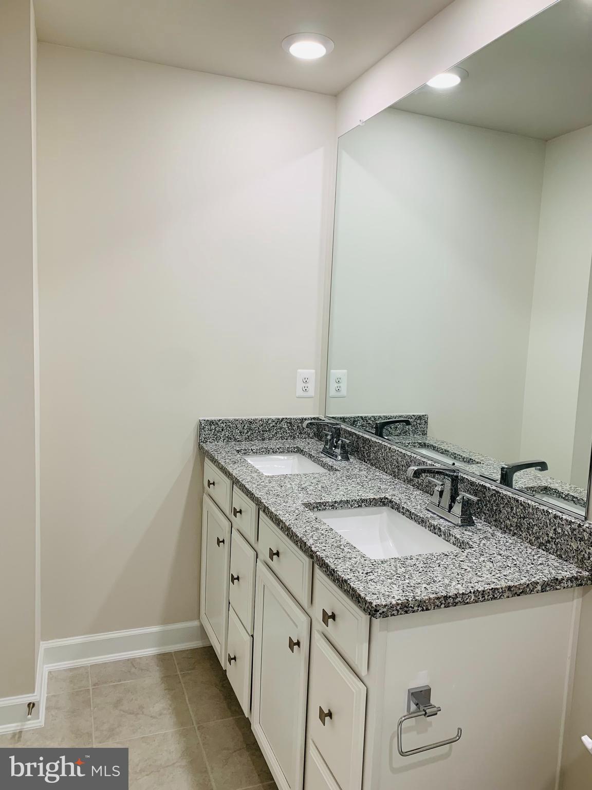 12884 Sunrise Ridge Alley, Unit 47 Herndon, VA 20171 - Photo 28 of 37 a bathroom with a granite countertop sink and a mirror