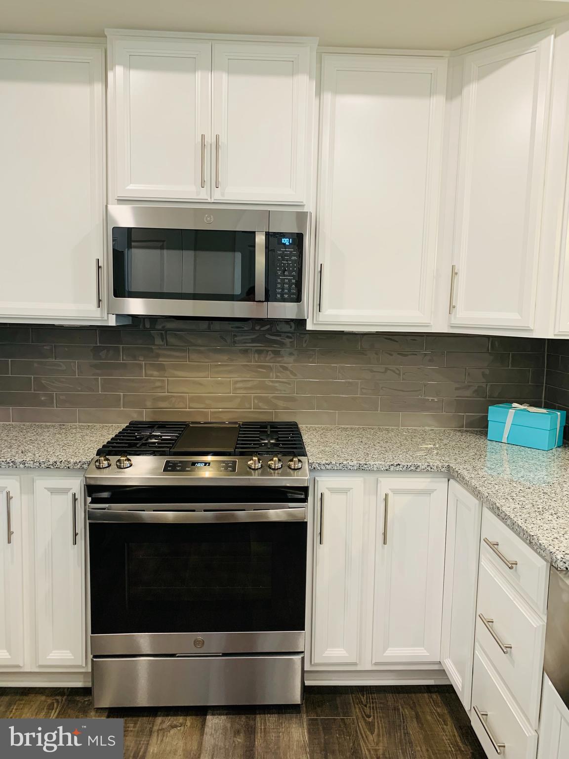 12884 Sunrise Ridge Alley, Unit 47 Herndon, VA 20171 - Photo 8 of 37 a kitchen with granite countertop a stove and a white cabinets