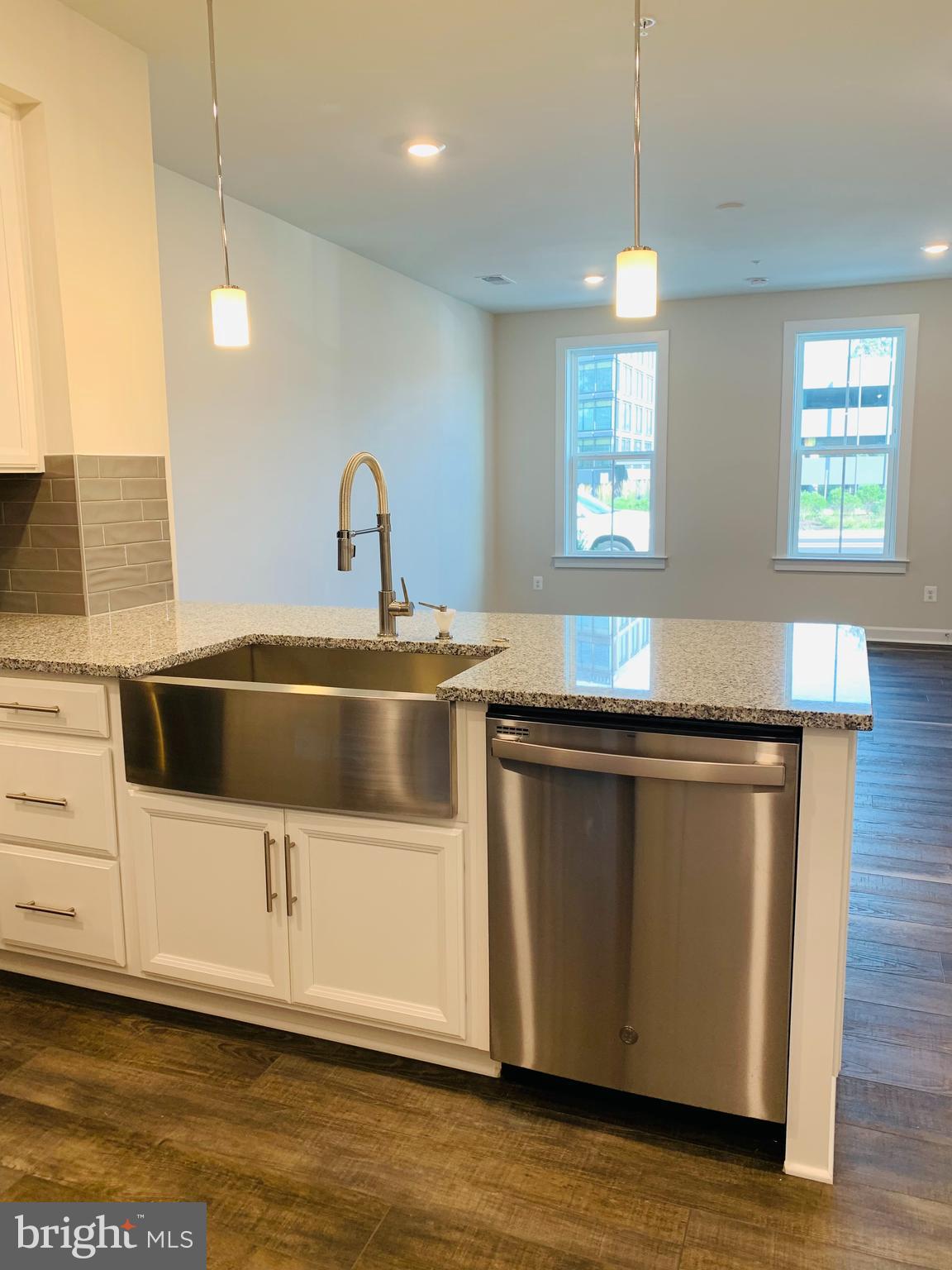 12884 Sunrise Ridge Alley, Unit 47 Herndon, VA 20171 - Photo 9 of 37 a kitchen with stainless steel appliances granite countertop a sink a stove and a microwave