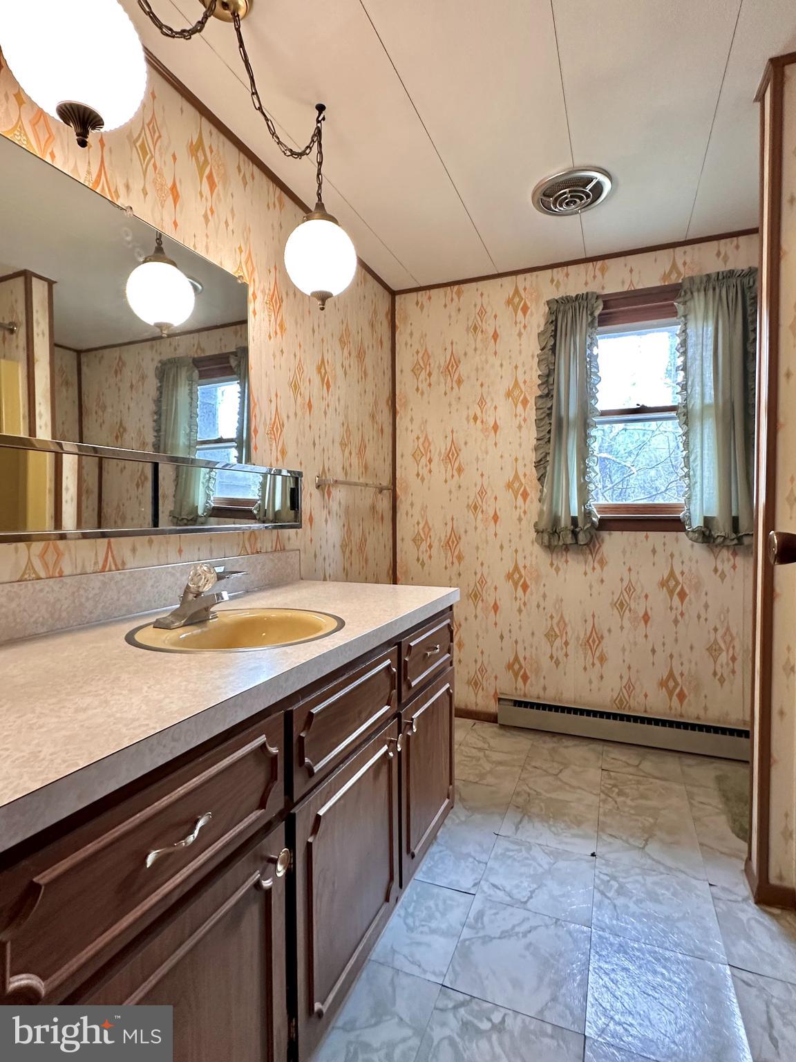 242 Gracey Road Waterfall, PA 16689 - Photo 12 of 40 a view of a bathroom with a sink a mirror and a bathtub