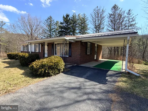 a front view of house with yard and trees in the background