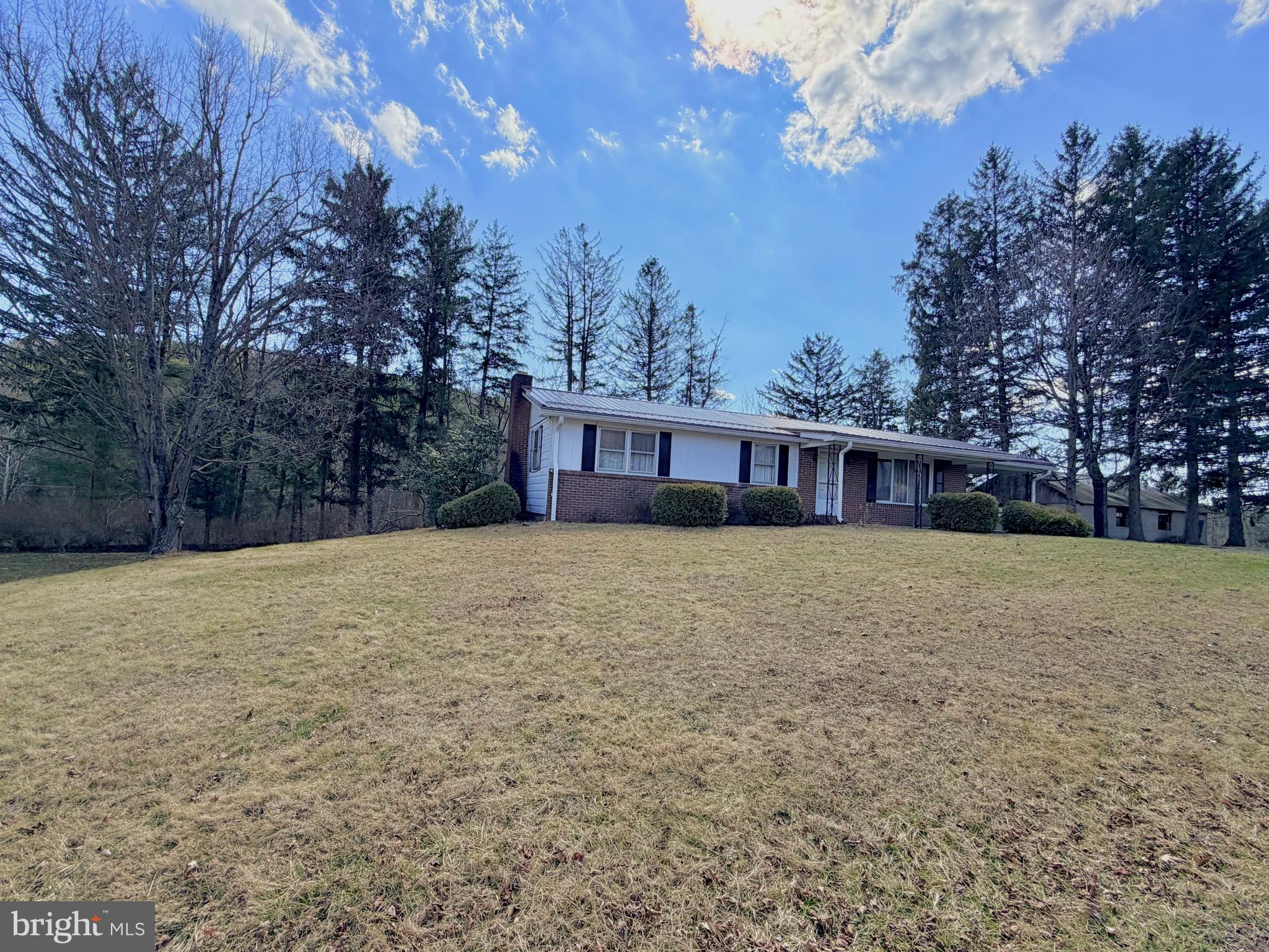 242 Gracey Road Waterfall, PA 16689 - Photo 33 of 40 a front view of house with yard and trees in the background
