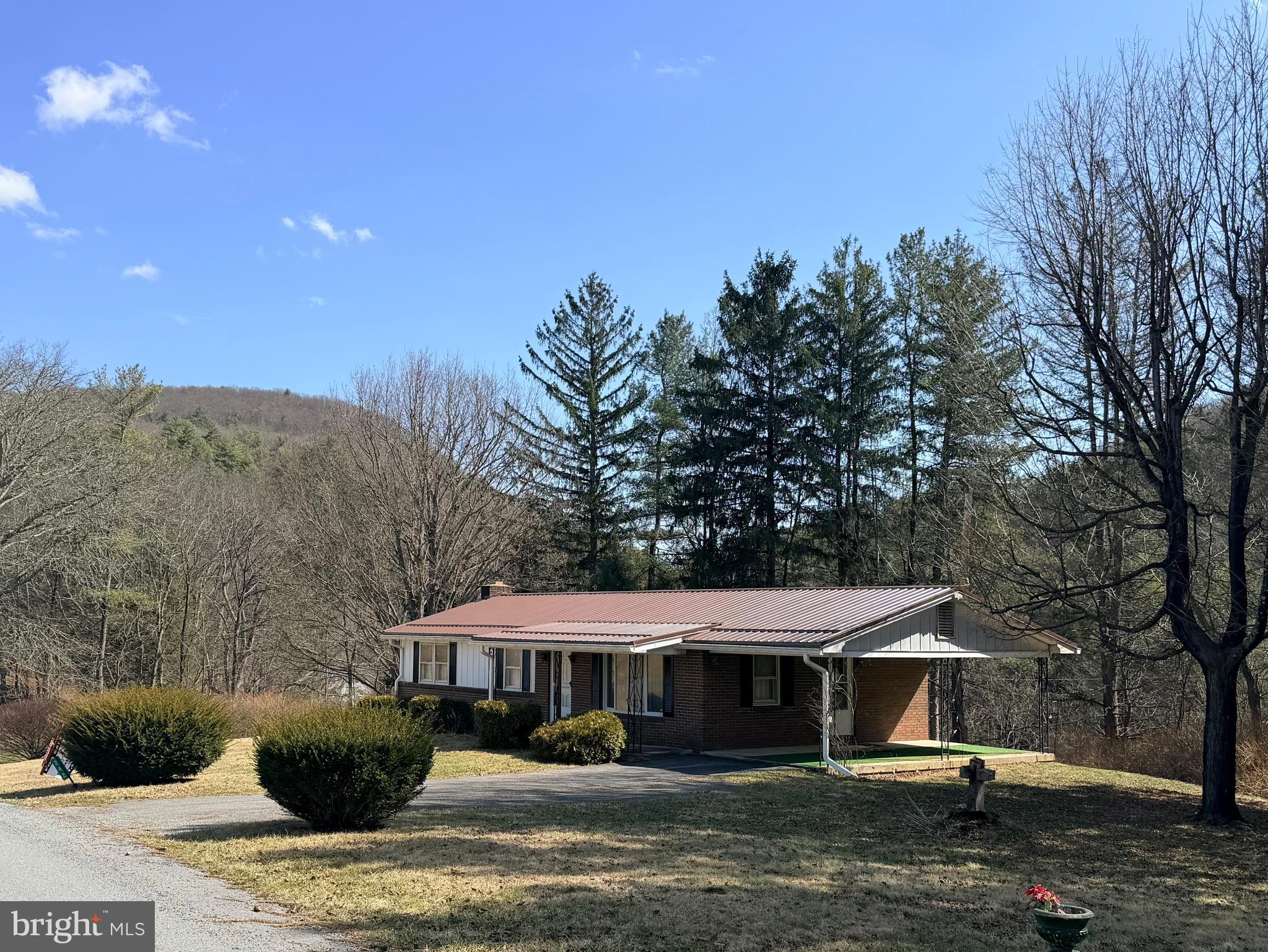 242 Gracey Road Waterfall, PA 16689 - Photo 40 of 40 a view of a big house with a fountain plants and large trees