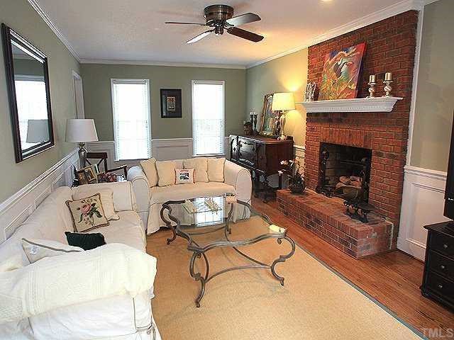 7320 Glendower Road Raleigh, NC 27613 - Photo 3 of 12 Front to back family room with refinished hardwoods, wainscoting, and gas log fireplace.