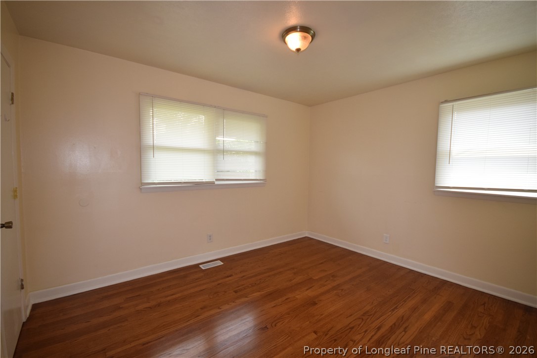 108 South 6th Street Spring Lake, NC 28390 - Photo 4 of 20 an empty room with wooden floor and windows