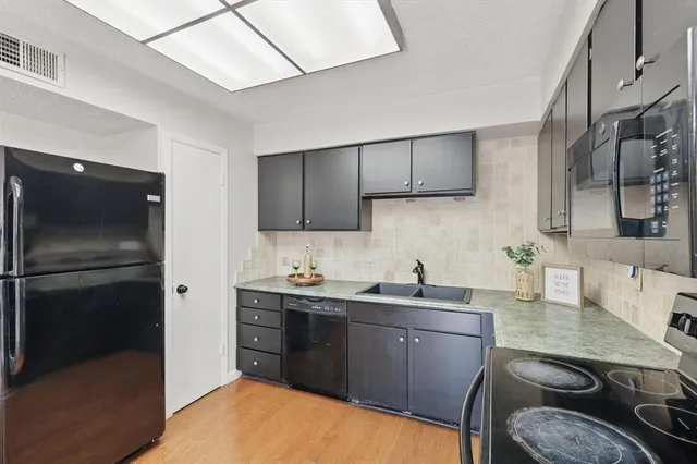 a kitchen with a sink appliances and cabinets