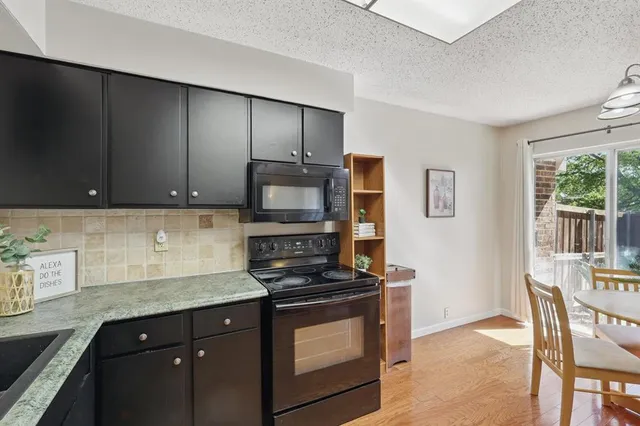 a kitchen with granite countertop wooden cabinets and a stove top oven