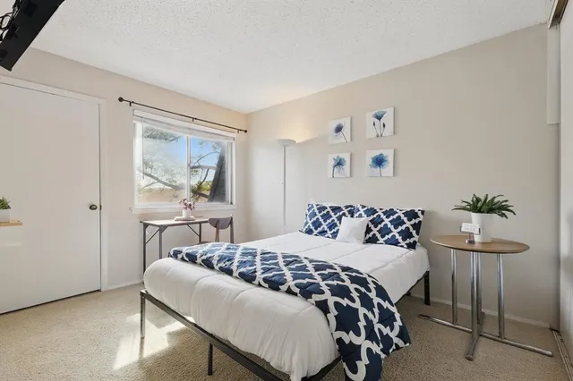 a bedroom with a bed and a painting on the wall