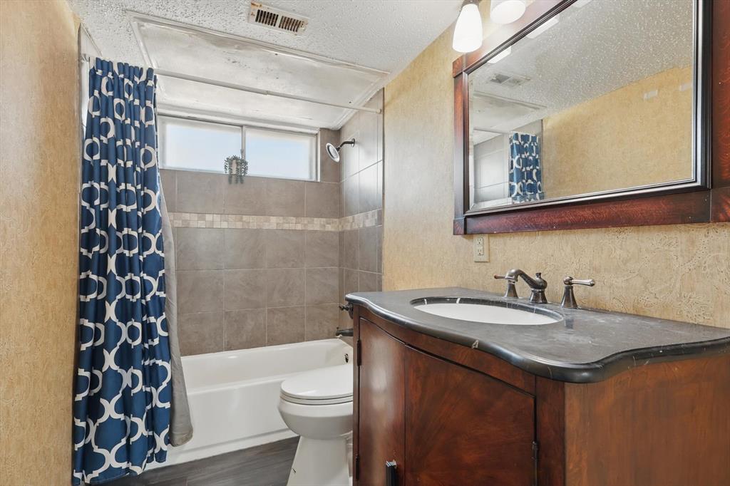 2700 Stonehaven Court Irving, TX 75038 - Photo 24 of 40 a bathroom with a sink a toilet a shower curtain and a mirror