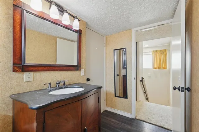 a bathroom with a sink a mirror a vanity and a shower