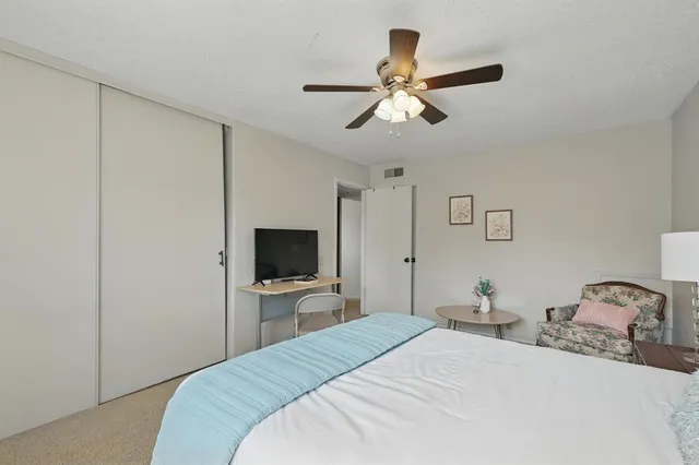 a bedroom with a bed and a flat tv screen on wall