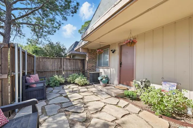 a view of a backyard with potted plants and a fountain