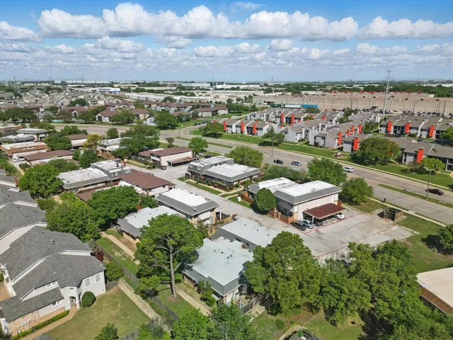 an aerial view of a city with lots of residential buildings ocean and mountain view in back