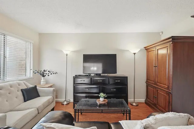 a living room with furniture a flat screen tv and a window