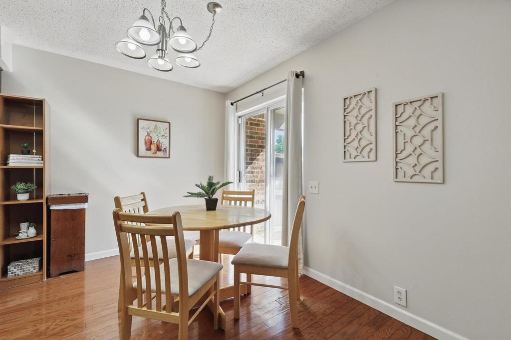 2700 Stonehaven Court Irving, TX 75038 - Photo 8 of 40 a view of a dining room with furniture wooden floor and a chandelier