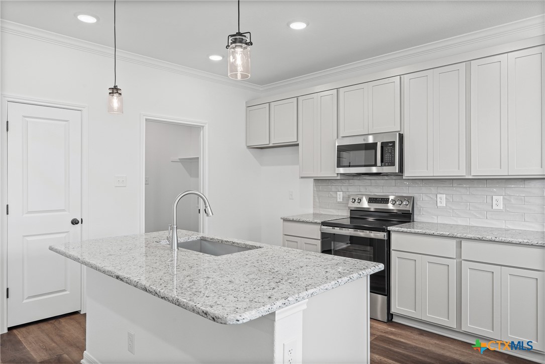 8023 Pineridge Way Temple, TX 76502 - Photo 16 of 28 a kitchen with stainless steel appliances granite countertop a sink a stove a oven a refrigerator with white cabinets and wooden floor
