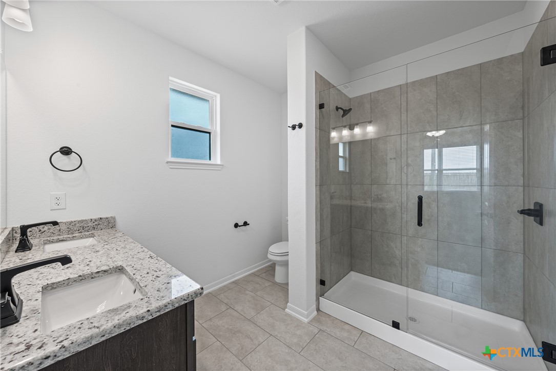 8023 Pineridge Way Temple, TX 76502 - Photo 24 of 28 a bathroom with a granite countertop sink a toilet and shower