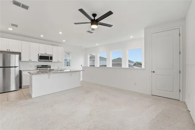 a view of kitchen with sink microwave and refrigerator