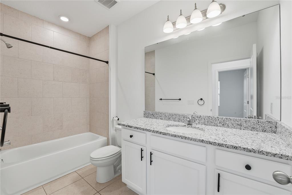 6552 Barnstorm Way St. Cloud, FL 34771 - Photo 17 of 17 a bathroom with a granite countertop sink a toilet and bathtub